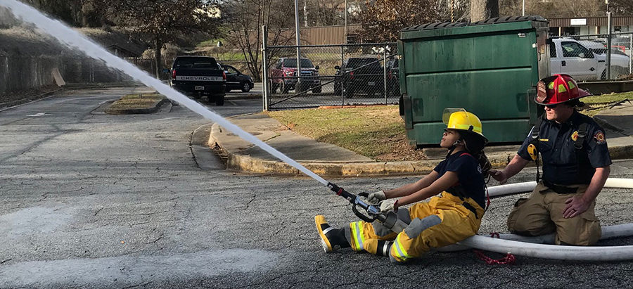 A cadet with the Covington Fire Explorer program receives training on handling a 2 1/2" handline.