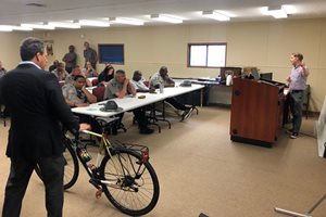 A man stands by a bike in a meeting